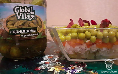 Переходите к заключительному этапу: соберите салат. Последовательность слоев: картофель, соус, курица, соус, морковь, корнишоны, грецкий орех, соус, горошек.