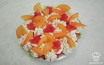 Хурму нарежьте дольками и разложите на каждый сливочный цветок по одно дольке .