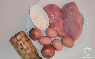 Если используйте замороженные грибы, то заранее позаботьтесь об их разморозке, а если свежие, то промойте их, удалив мусор, и почистите. После этого обжарьте их на растительном масле с измельченным луком. Куриную грудку заранее отварите в подсоленной воде и нарежьте на средние кусочки. Твердый сыр потрите на крупной терке. Куриные яйца отварите и разделите на белки и желтки.