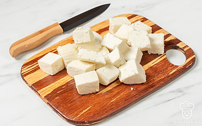 Добавьте в сковороду 1 ст.л. растительного масла. Поставьте ее на средний огонь и разогрейте. Панир нарежьте небольшими кубиками.