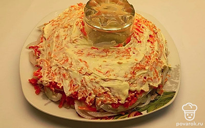 Следом за курицей выложите маринованный в уксусе лук и смажьте его тонким слоем майонеза. На лук выложите натертую морковь и также смажьте майонезом.