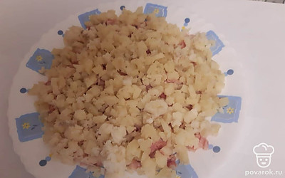 Картофель отварить, мелко нарезать кубиками, выложить в салатник, смазать немного майонезом.