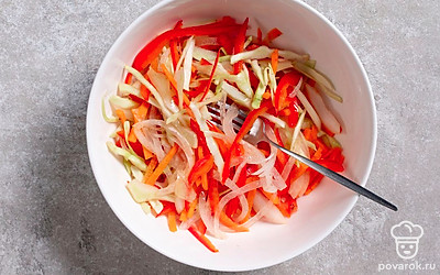 Заправьте салат с капустой и морковью уксусной заправкой и перемешайте. Дайте закуске настояться в течение 10 минут. 