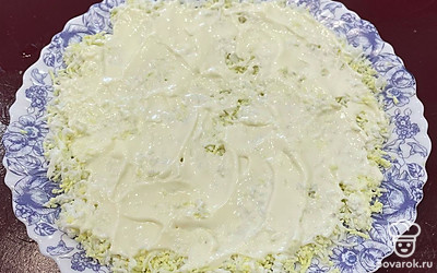 Отварите яйца вкрутую, охладите под холодной водой и натрите на крупной терке. Это будет первый слой. Смажьте его майонезом.