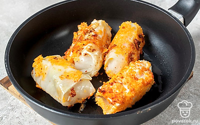 Разогрейте на сковороде растительное масло. Обжарьте завернутые в капусту сосиски 5 минут со всех сторон на среднем огне.