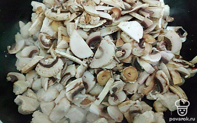 Шампиньоны мелко нарежьте добавьте на сковороду к обжаренной грудке. Обжаривайте грибы с мясом до испарения влаги.