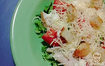 Сверху на салат натереть сыр и выложить сухарики.