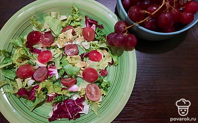 Выложите микс салатов на порционные тарелки вместе с виноградом.