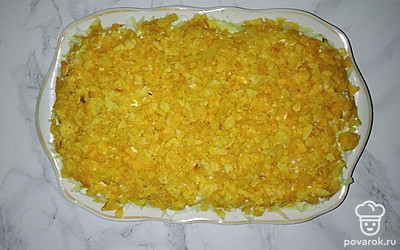 Выкладывайте салат по слоям: куриное филе, морковь, апельсин, сыр, яйца, измельченные чипсы. Смазывайте майонезом все слои, кроме последнего.