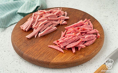 Нарежьте оба вида колбасы тонкой соломкой.