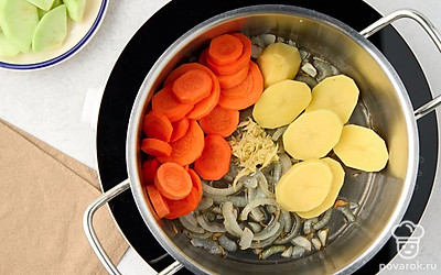 В большой кастрюле нагрейте оливковое масло на среднем огне. Добавьте лук и чеснок и жарьте около 5 минут, постоянно помешивая. Затем добавьте морковь, яблоко, картофель и имбирь. Обжаривайте еще 5-6 минут.