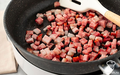 Нарежьте бекон на небольшие кусочки. Разогрейте сухую сковороду на среднем огне. Обжарьте бекон в течение 3 минут, часто помешивая.