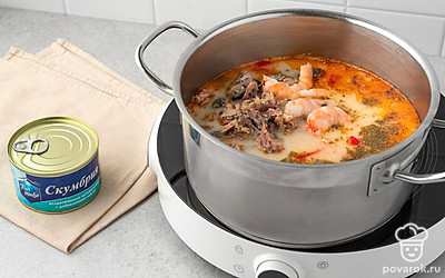 Разломайте скумбрию на кусочки. Выложите в кастрюлю креветки и консервированную скумбрию. Перемешайте. Дайте супу покипеть 2 минуты и отключите нагрев.