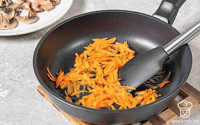 Нарежьте шампиньоны пластинками. Обжарьте в масле 7 минут. Выложите на тарелку. Натрите морковь и обжарьте на той же сковороде 5 минут. 