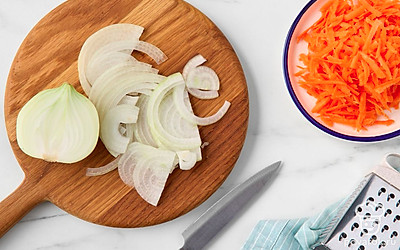 Нарежьте лук полукольцами толщиной 2-3 мм. Крупно натрите морковь.