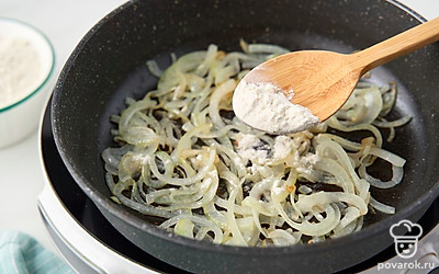 Всыпьте к луку пшеничную муку. Прогрейте, все время перемешивая, еще 2-3 минуты до светло-бежевого цвета.