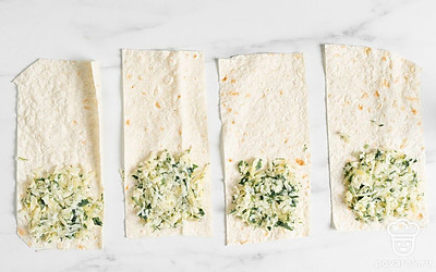 Выложите примерно 1-2 столовые ложки начинки в начало полоски.