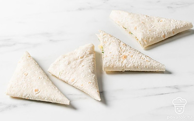 Заверните край со стороны начинки треугольником и складывайте так до конца полоски. Получатся вот такие пирожки.