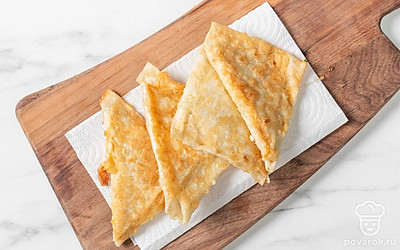 Застелите плоскую тарелку или кухонную доску салфетками в несколько слоев, разложите горячие пирожки. Оставьте на 2-3 минуты, чтобы бумага впитала лишнее масло. 