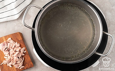 Достаньте готовую курицу из бульона, отделите мясо от костей и кожи. Нарежьте куриное мясо небольшими кусочками. Процедите бульон через сито и снова поставьте на огонь чуть выше среднего.