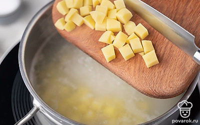 Добавьте в кастрюлю с рисом картофель, соль и перец. Перемешайте. Готовьте суп 15 минут.