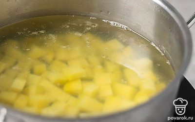 Нарежьте картофель мелкими кубиками или брусочками. Отправьте их в кипящую воду. Уменьшите огонь до среднего и прикройте кастрюлю крышкой.
