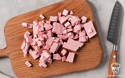 Нарежьте колбасу небольшими кубиками. Отправьте ее в бульон с овощами. Все перемешайте. Накройте крышкой и дайте покипеть 1-2 минуты.