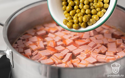 Высыпьте в суп консервированный зеленый горошек. Посолите бульон по вкусу. Перемешайте и снимите кастрюлю с огня. Дайте супу настояться под закрытой крышкой пару минут. 