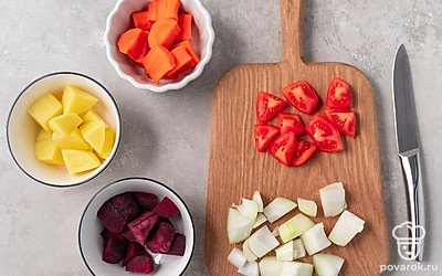 Нарежьте на кубики среднего размера картофель, свеклу, морковь, помидор и лук.