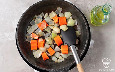 Разогрейте в глубокой сковороде растительное масло. Обжарьте лук и морковь в течение 15 минут на среднем огне, регулярно перемешивая.