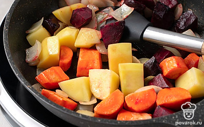 Добавьте на сковороду свеклу и картошку, готовьте еще 15 минут, периодически перемешивая. Положите в сковороду помидор. Тушите овощи еще 10 минут.