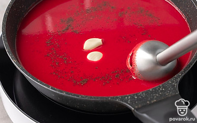 Отключите нагрев. Уберите лавровый лист. Пробейте содержимое сковороды блендером. Добавьте чеснок и еще раз хорошенько измельчите блендером. Добавьте черный молотый перец. Перемешайте. Оставьте борщ настаиваться 10 минут.