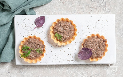 Разложите готовую икру из грибов по тарталеткам, украсьте зеленью и подавайте закуску на стол.