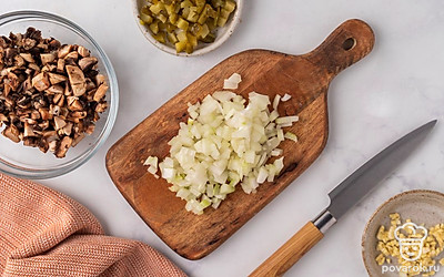 Измельчите мелкими кубиками лук, маринованные огурцы и чеснок. Нарежьте шампиньоны небольшими кусочками.