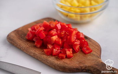Нарежьте картофель и помидоры средними кубиками.