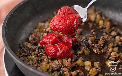 Добавьте к овощам с грибами томатную пасту. Еще раз хорошо перемешайте. Уберите сковороду с плиты.