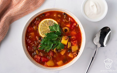 Украсьте солянку дольками лимона, веточкой петрушки и подайте на стол в горячем виде.