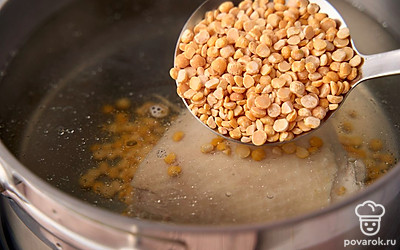 Верните мясо в кастрюлю и заново залейте 2 литрами чистой воды. Поставьте на сильный огонь. Как только вода закипит, убавьте нагрев. Выложите горох в кастрюлю. Варите до мягкости гороха. На это уйдет около 1 часа. За 10 минут до готовности посолите бульон по вкусу.