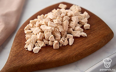 Достаньте из бульона готовую курицу. Слегка остудите ее, отделите от костей, нарежьте небольшими кусочками. Верните нарезанное мясо обратно в суп.