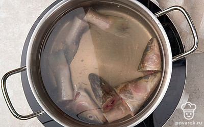 Отрежьте у рыбы голову и хвост. Переложите их в кастрюлю и залейте водой.