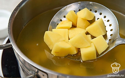 Нарежьте картофель небольшими кубиками и переложите в кипящий бульон вместе с несколькими щепотками соли. Перемешайте и доведите суп до кипения.