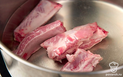 Налейте в кастрюлю 1 стакан воды. Поставьте на сильный огонь и доведите воду до кипения. Разрежьте ребрышки на 4 части между косточками и положите их в кипящую воду. Бланшируйте мясо примерно 2 минуты. 