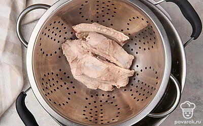 Выложите ребрышки в дуршлаг, промойте их от образовавшейся накипи. Вымойте кастрюлю, налейте в нее оставшуюся чистую воду.