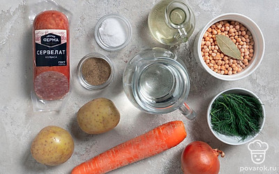 Помойте и почистите картошку, морковку, лук. Промойте под проточной водой горох. Залейте горох холодной водой на 3 часа или на ночь. Потом еще раз его промойте. Снимите пленку с сервелата.