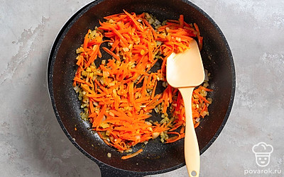 Натрите морковь на средней терке. Мелко покрошите репчатый лук. Разогрейте в сковороде растительное масло. Обжарьте лук с морковкой 10 минут, регулярно перемешивая.