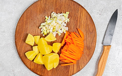 Нашинкуйте лук четвертинками колец, измельчите морковь тонкими брусочками. Нарежьте картофель кусочками размером около 2 см.