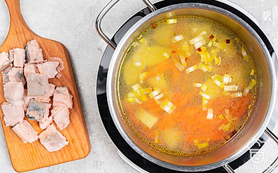 Выложите обжаренные овощи в кипящий бульон с рыбой. Добавьте картофель. Поварите уху 7-10 минут до готовности горбуши. Достаньте рыбу из бульона и нарежьте на более мелкие кусочки.