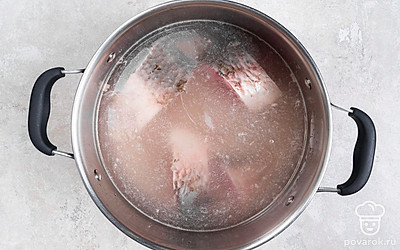 Разрежьте рыбу на 3-4 части, выложите их в кастрюлю. Залейте рыбу водой, поставьте кастрюлю на огонь выше среднего. Дождитесь кипения, убавьте огонь и варите бульон около 30 минут.