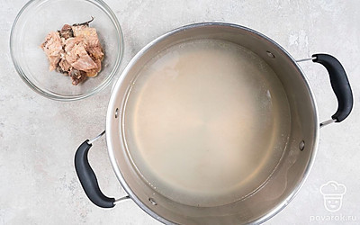 Достаньте из готового бульона рыбу, отделите мякоть от кожи и костей. Процедите бульон в миску и снова перелейте в кастрюлю. Поставьте ее на средний огонь, доведите бульон до кипения.