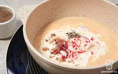 Крабовую палочку мелко нарежьте и добавьте в суп. Поперчите и перемешайте.